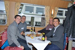 4 Personen am Tisch sitzend.