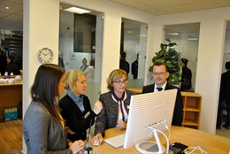 Mehrere Personen vor einem Bildschirm im Gespräch.